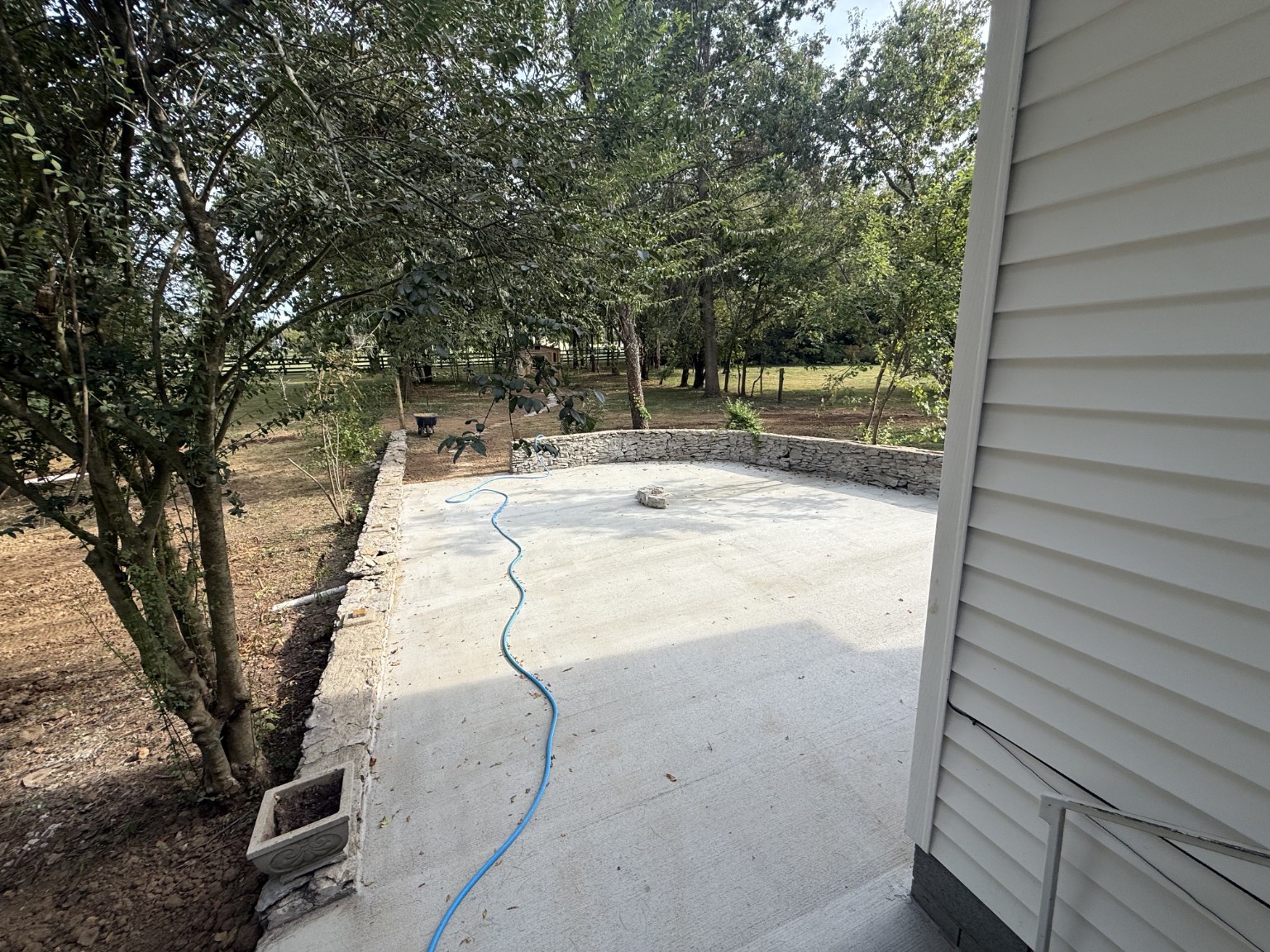 Concrete patio with stone wall completed project